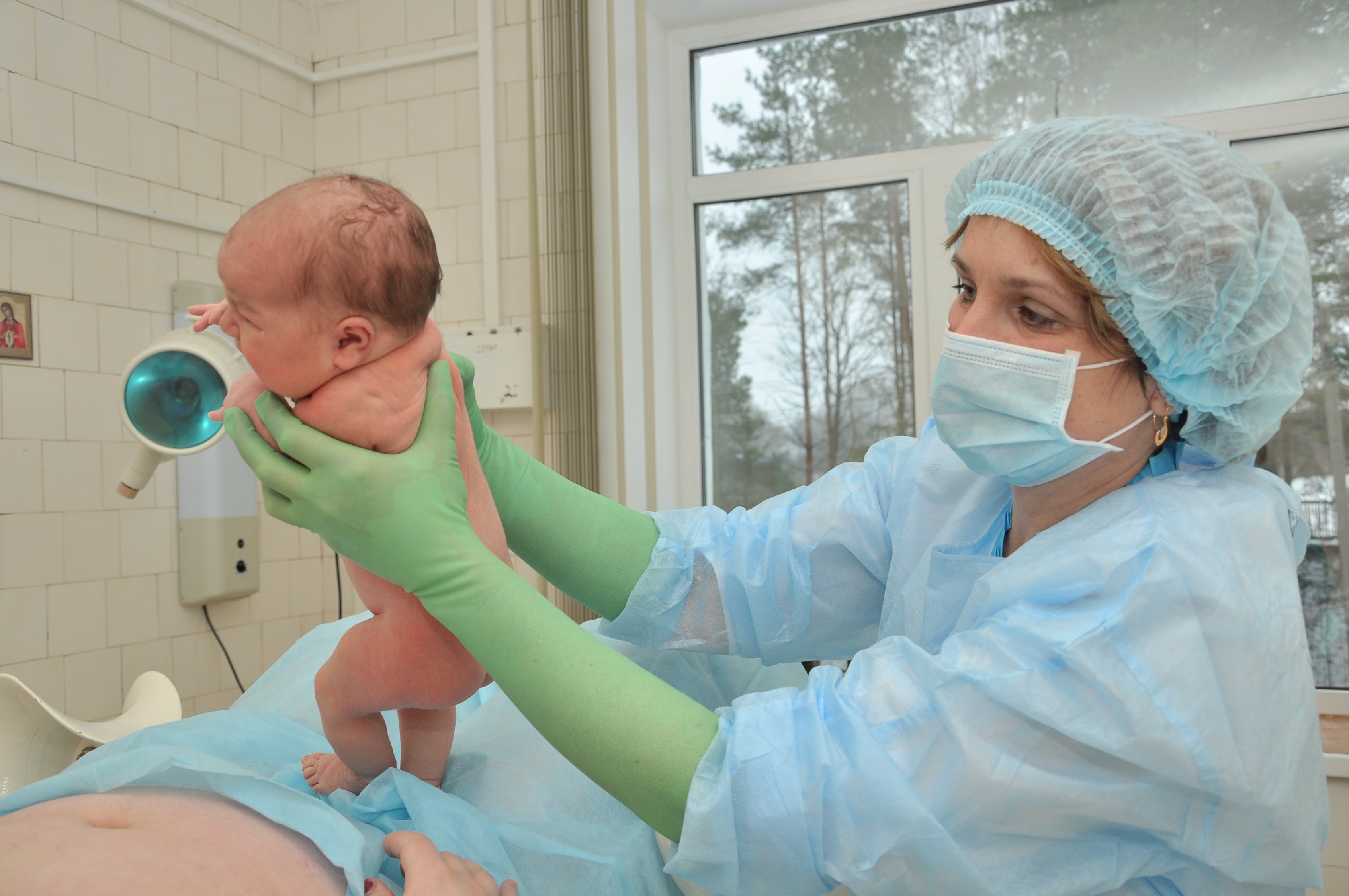 new born baby being held by nurse in OR