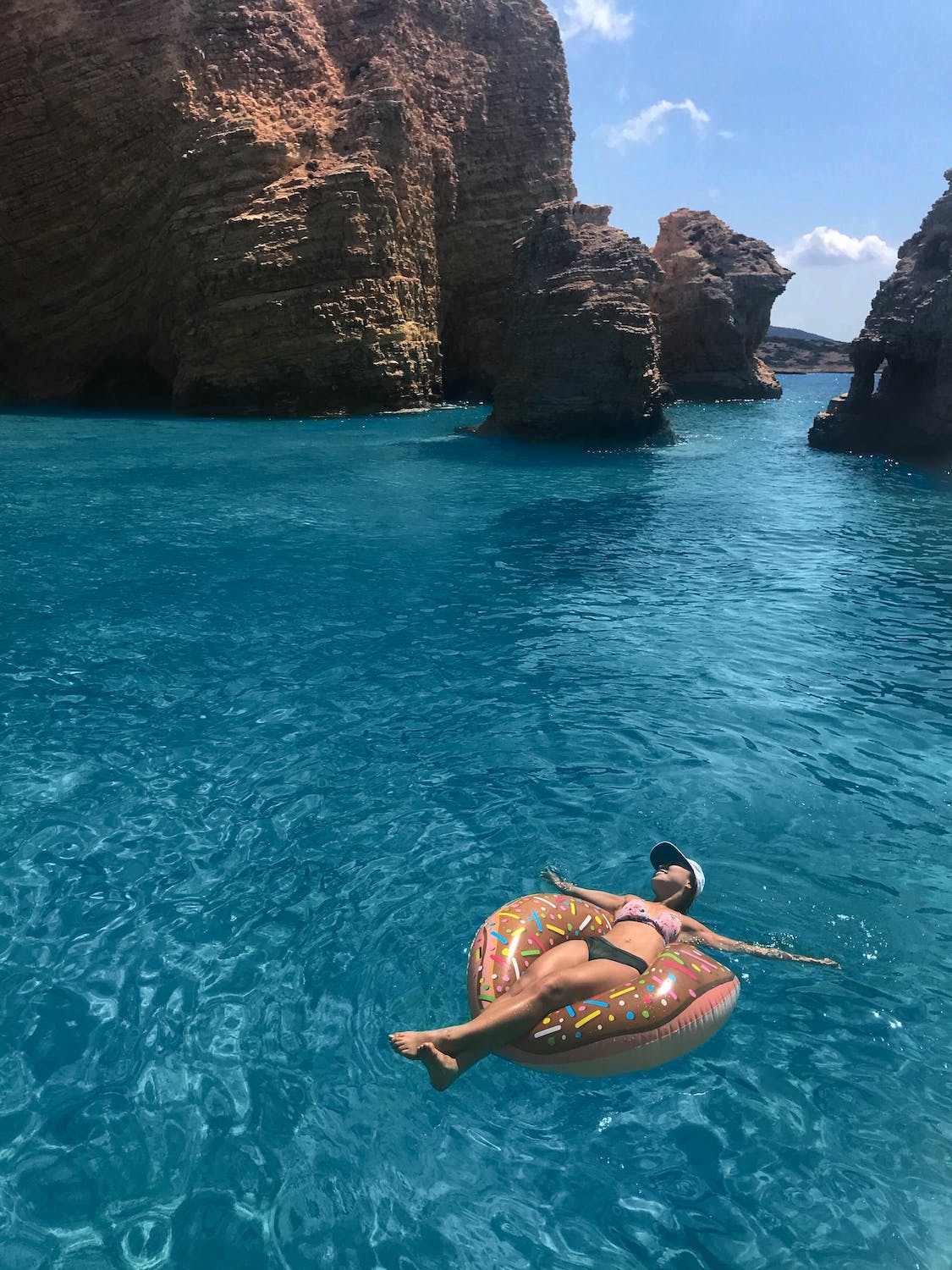 woman floating in blue water on a inflatable ring