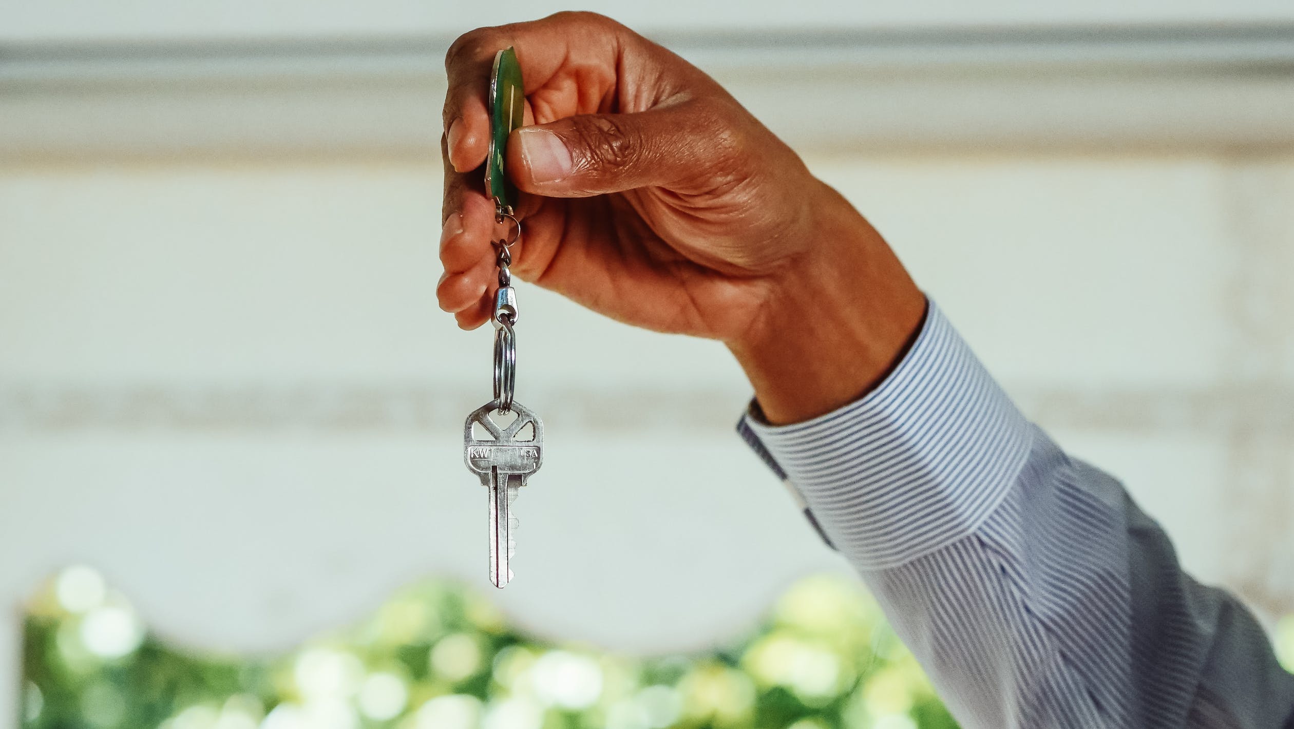 hand holding a single key on a chain